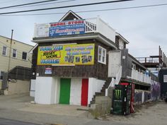 an old building with posters on the side of it and other buildings in front of it