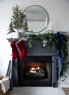 a christmas fireplace with stockings hanging from it's mantle and decorations on the mantle