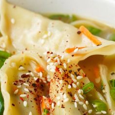 a bowl filled with noodles and vegetables covered in seasoning sprinkled on top