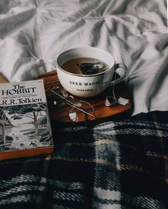 a bowl of soup and some books on a bed