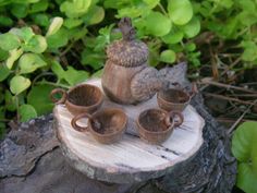 a small bird figurine sitting on top of a wooden tray filled with coffee cups