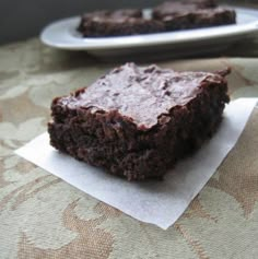 two pieces of brownie sitting on top of a table