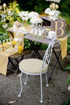 the table is set with yellow and white flowers