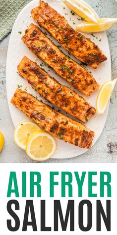 air fryer salmon on a white plate with lemons and parsley next to it