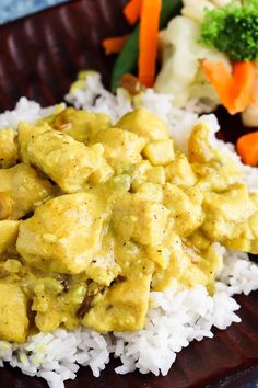 a plate with rice, chicken and vegetables on it next to some broccoli