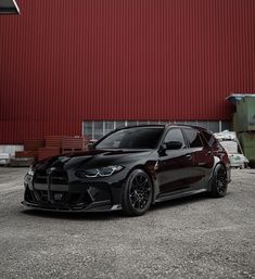 a black car parked in front of a red building