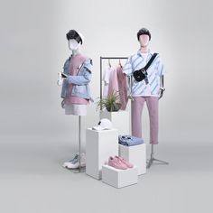 two mannequins dressed in pink and blue clothing, one holding a camera