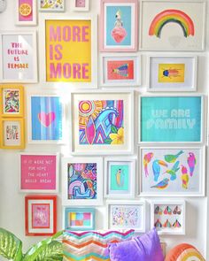 there are many pictures on the wall and one is pink, blue, yellow, green