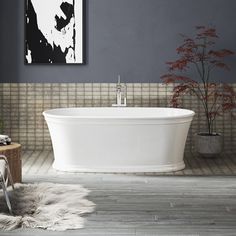 a white bath tub sitting in a bathroom next to a painting on the wall above it