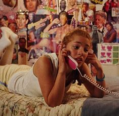 a woman laying on her bed talking on the phone