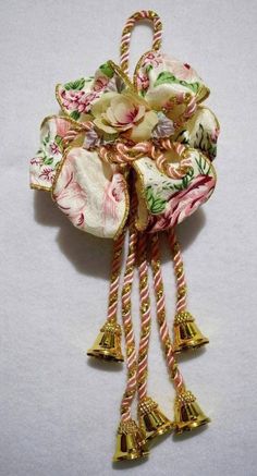 a close up of a flower and bells on a white surface with gold bell decorations