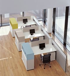 an office cubicle with multiple desks and chairs in it, along with large windows