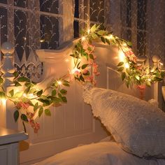 a bed with flowers and lights on the headboard