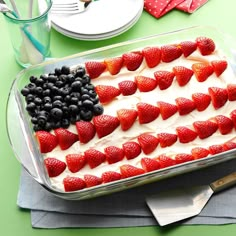 an american flag cake with strawberries and blueberries in the middle on a table