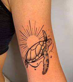 a woman's arm with a turtle tattoo on it