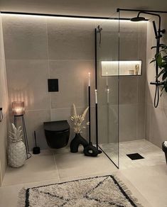 a bathroom with a black toilet and white rug on the floor next to a shower