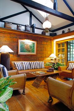 a living room filled with lots of furniture and decor on top of a hard wood floor