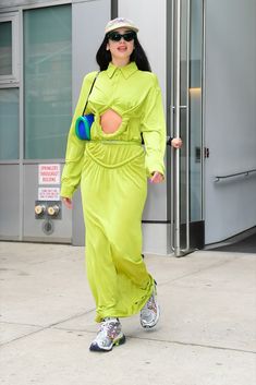 a woman walking down the street in a yellow outfit