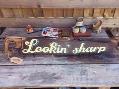 a wooden sign that says lookin'sharp on the side of a bench with other items around it