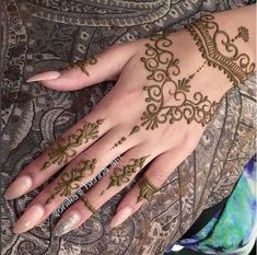 a woman's hand with henna tattoos on it