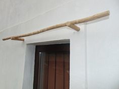 a wooden stick sticking out of the side of a white wall next to a door