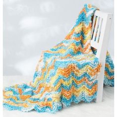 a crocheted blanket sitting on top of a white chair