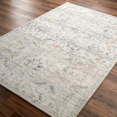 an area rug on the floor with wooden floors and hard wood flooring in front of it