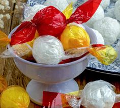 two bowls filled with different colored candies on top of a wooden table