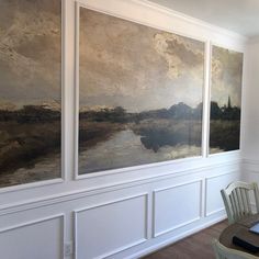 three paintings are hanging on the wall above a dining room table