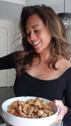 a woman holding a bowl of food in her hands