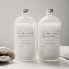 two white bottles sitting next to each other on a table with towels and a banana