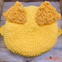 a crocheted yellow beanie with two brown ears