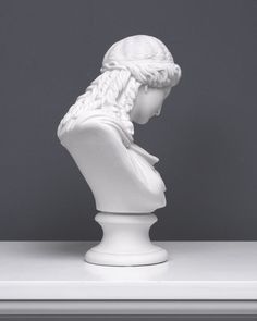 a white busturine with braids on it's head sitting on a table