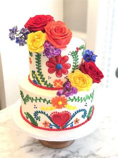 a multi - tiered cake decorated with colorful flowers