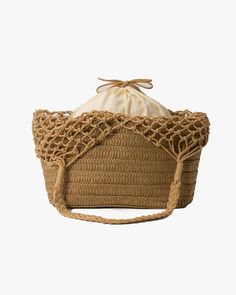 a large brown basket with a drawstring on the side and a white bag in the back