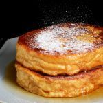 two pancakes with powdered sugar on top