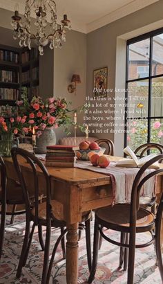 a dining room table with flowers and books on it