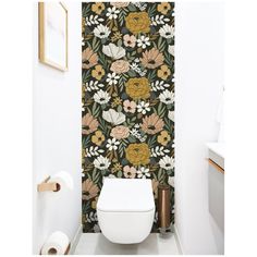 a white toilet sitting in a bathroom next to a wallpaper with flowers on it