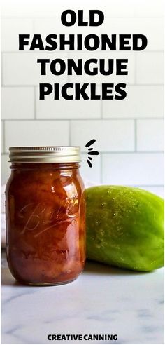 an old fashioned pickle jar next to a cucumber on a white counter