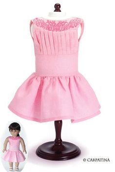 the doll is wearing a pink dress