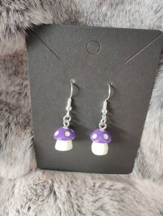 a pair of purple and white mushroom earrings