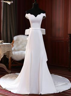 a white wedding dress on display in a room