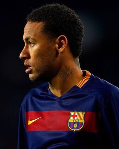 a close up of a soccer player wearing a blue shirt with red and yellow stripes