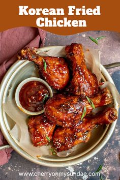 korean fried chicken on a plate with dipping sauce