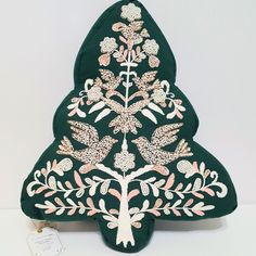 a decorative tree shaped cushion with pink and white flowers on it's side, sitting on a table