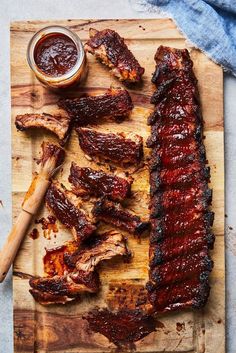 barbecue ribs on a cutting board with bbq sauce