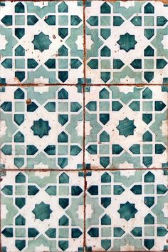 an old tiled wall with blue and white tiles on the bottom, in different shapes