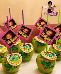 there are some green apples with pictures on them and straws in front of them