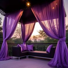 a purple canopy bed sitting on top of a wooden deck