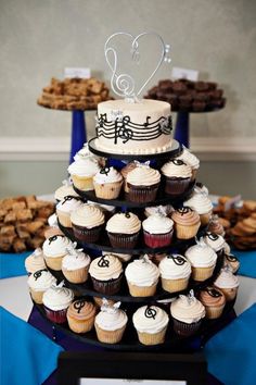 cupcakes are arranged in the shape of a music note on top of a tiered cake